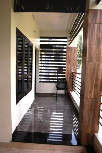 a hallway of a house with a chair on the floor at ECOSTAY inn in Sultan Bathery