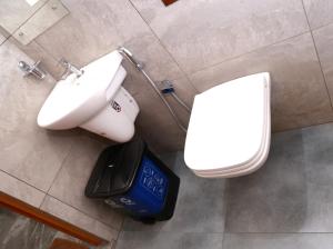 a bathroom with a sink and a toilet and a scale at ECOSTAY inn in Sultan Bathery