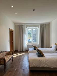 a hotel room with two beds and a window at Château du Pont d'Oye in Habay-la-Neuve