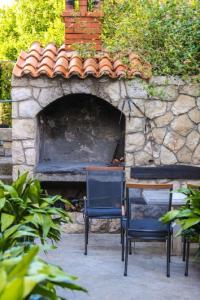 two chairs and a table in front of a stone oven at Apartments Dia in Dubrovnik