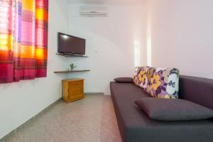 a living room with a couch and a flat screen tv at Apartments Dia in Dubrovnik