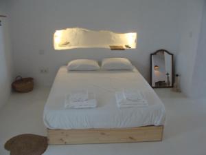 - une chambre avec un lit doté de draps blancs et d'un miroir dans l'établissement Casas Velhinhas - Apartº Aconchego e Apartº Calmaria, à Estremoz