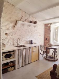 - une cuisine avec un évier et une table dans une chambre dans l'établissement Casas Velhinhas - Apartº Aconchego e Apartº Calmaria, à Estremoz