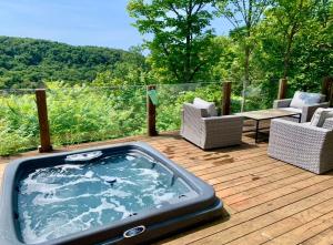 - un bain à remous sur une terrasse avec des chaises et une table dans l'établissement Blue Hill Pool spa game room mountain view, à Morin Heights