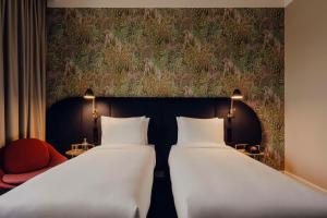 two beds in a room with a wall mural at Flaner Hotel, WorldHotels Crafted in Warsaw