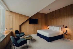 a hotel room with a bed and a chair at Flaner Hotel, WorldHotels Crafted in Warsaw