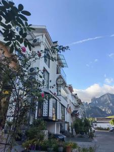 a white building with a clock on it at Flower Whisperer Homestay in Zhangjiajie