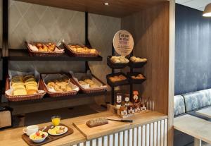 un panificio con vari prodotti da forno e pane in cesti di B&B HOTEL Cergy Pierrelaye a Pierrelaye