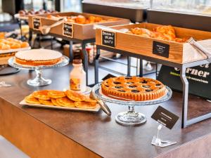 a bakery with pies and pastries on a counter at B&B Hotel Milano Aosta in Milan