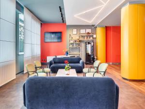 a waiting room with two blue couches and chairs at B&B Hotel Milano Aosta in Milan