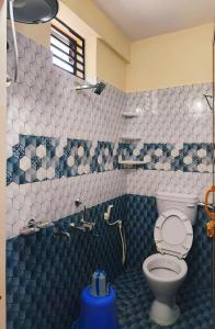 un bagno blu e bianco con servizi igienici e doccia di Nellakki Homestay a Madikeri