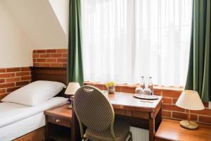 - une chambre avec un bureau, un lit et une table dans l'établissement Hotel Szymbark, à Szymbark