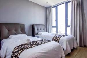 een kamer met 3 bedden en een raam bij Jazz Service Suites Penang in George Town