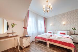 a bedroom with two beds and a mirror and a chandelier at Hotel POD HERBEM -POKOJE OZONOWANE in Białystok