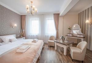 a bedroom with a large bed and a desk and a mirror at Hotel POD HERBEM -POKOJE OZONOWANE in Białystok