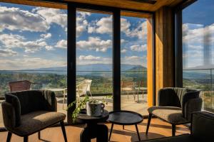 um quarto com uma grande janela com cadeiras e uma mesa em The Pines Bucegi Lodge em Bran