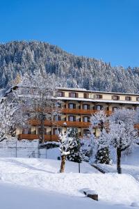 un edificio con árboles nevados delante de él en Villars Lodge, en Villars-sur-Ollon