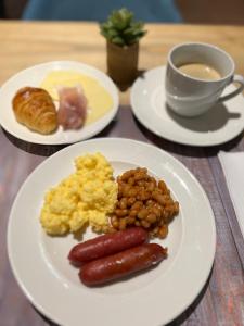 uma mesa com dois pratos de comida e uma chávena de café em Hotel Douglas em Puteaux