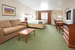 um quarto de hotel com uma cama e um sofá em Holiday Inn Express Hotel & Suites Gunnison, an IHG Hotel em Gunnison