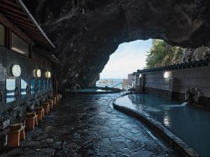 una piscina en una cueva junto a un edificio en Hotel Urashima, en Katsuura