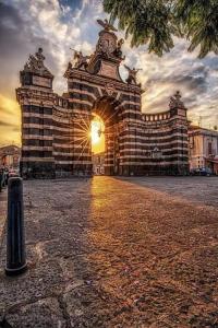 ein großes Gebäude mit einem Sonnenuntergang davor in der Unterkunft King House Catania Hostel Ostello in Catania