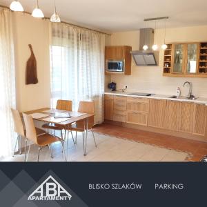 una cucina con tavolo e una sala da pranzo di PRESTIGE PARK apartament z tarasem i parkingiem a Krynica-Zdrój