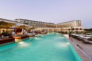 um hotel com piscina em frente a um edifício em Ethno Belek em Belek