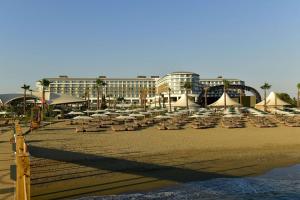 uma praia arenosa com espreguiçadeiras e um edifício em Ethno Belek em Belek