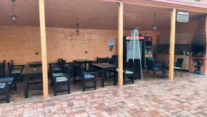 un restaurant avec des tables et des chaises en bois et un mur en briques dans l'établissement Casa SOL, à Turda