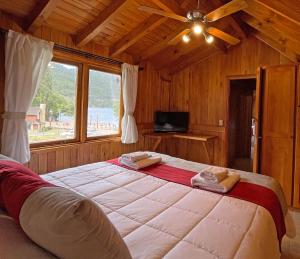 uma cama grande num quarto com uma janela grande em Apart Hotel Orilla Mansa by Visionnaire em San Martín de los Andes