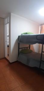 Habitación con 2 literas y pasillo. en Urpi Wasi Backpackers, en Puno