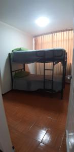 Litera en habitación con suelo de madera en Urpi Wasi Backpackers, en Puno