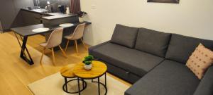 un soggiorno con divano e tavolo di New apartment with free parking near the airport a Prievoz