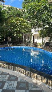 una gran piscina azul con gente en el agua en Vientiane Garden Villa Hotel And Coffee, en Vientiane