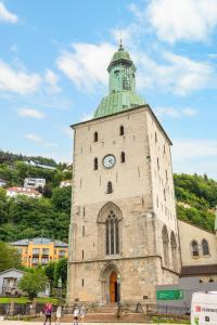 un edificio con una torre de reloj con techo verde en BUDGETEL- Kong Oscarsgate 44, en Bergen