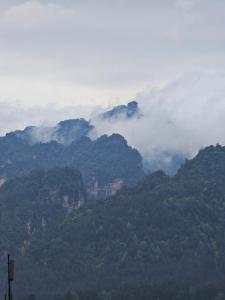 widok na pasmo górskie z chmurami w tle w obiekcie Lucky Praised Scenery Hotel w mieście Zhangjiajie