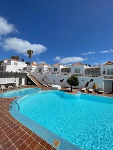 uma grande piscina num resort com edifícios brancos em Las Casitas de Corralejo em Corralejo