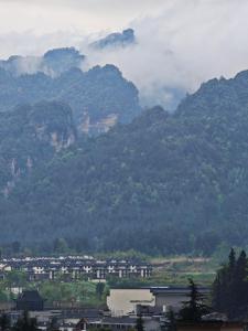 grupa budynków przed górą w obiekcie Lucky Praised Scenery Hotel w mieście Zhangjiajie