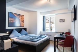 a bedroom with a bed and a desk and a table at HITrental Old Town Apartments in Luzern