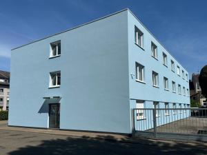 un edificio bianco con una recinzione di fronte di Eisberg Hotel Schwanen a Lahr