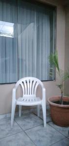 un banc blanc assis sur une terrasse couverte à côté d'une plante dans l'établissement El descanso céntrico, à Santa Cruz de la Sierra