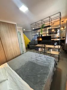 a bedroom with a bed and a living room at Flat Luxuoso Biena Sena Madureira Vila Mariana com garagem 1009 in Sao Paulo