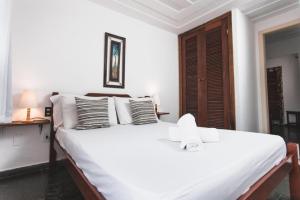 a bedroom with a large white bed with pillows at Peixe Crew Centro in Búzios