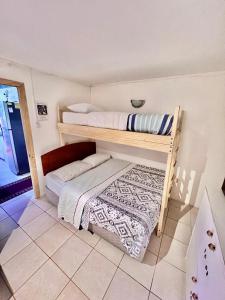 Habitación con 2 literas y suelo de baldosa. en Hostal Brisas del Sur, en Puerto Varas