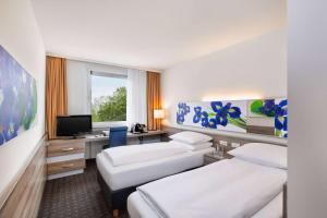 Tempat tidur dalam kamar di H+ Hotel Frankfurt Airport West