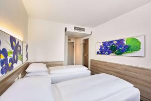 Tempat tidur dalam kamar di H+ Hotel Frankfurt Airport West