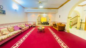 uma sala de estar com sofás e um tapete vermelho em Holiday Home Rent villa em Sharjah