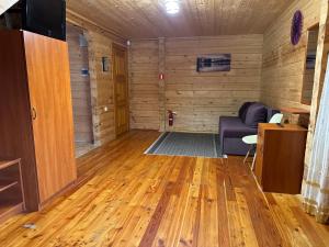 a living room with wood floors and a couch at Arnika in Skhidnitsa