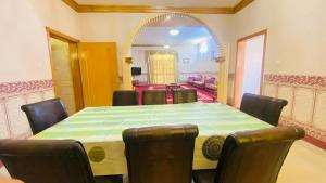 uma sala de jantar com uma mesa, cadeiras e um espelho em Holiday Home Rent villa em Sharjah