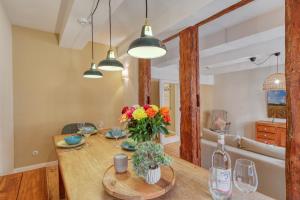 een eetkamer met een houten tafel met bloemen erop bij Ferienwohnungen Steinweg 61 in Quedlinburg